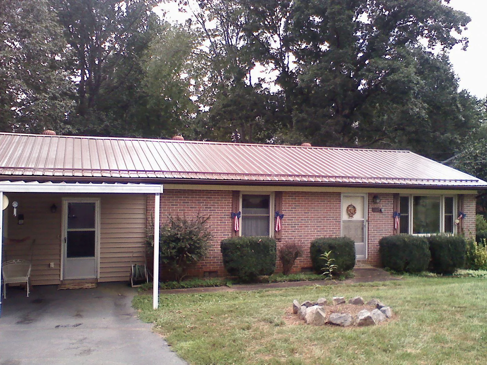 Bronze metal roof and carport on a brick ranch home — Roof Repair work by our crew in Pelham